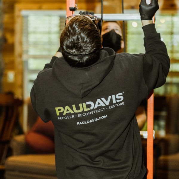 worker-on-ladder-in-paul-davis-hoodie-repairing-home-interior-tigard